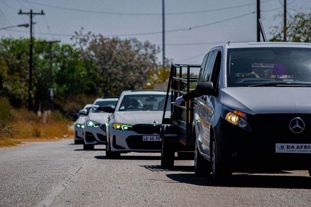 A BaAfrica hearse leading a convoy of family cars on the road out of Rustenburg