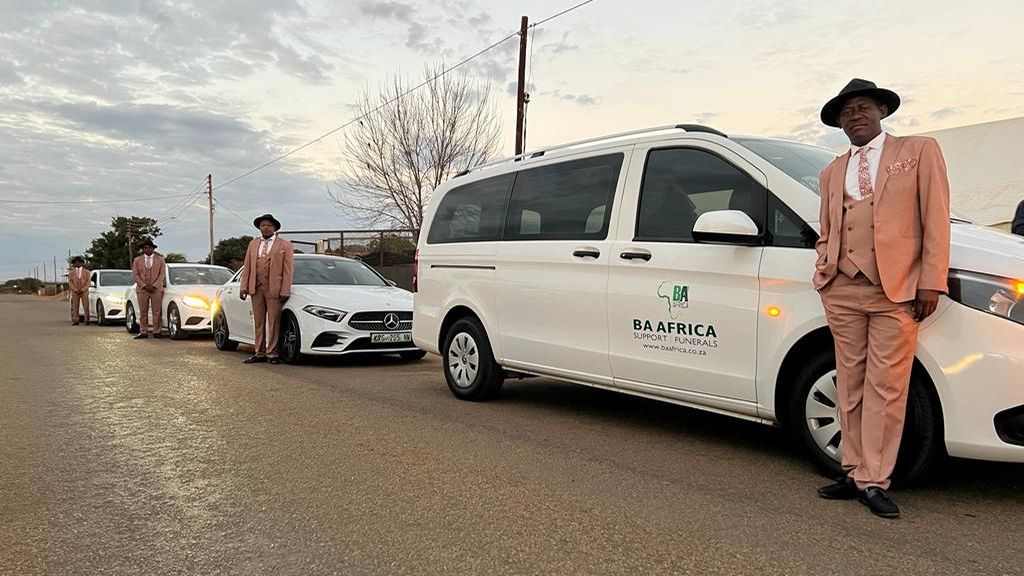 The BaAfrica fleet lined up at dawn, drivers standing by each vehicle