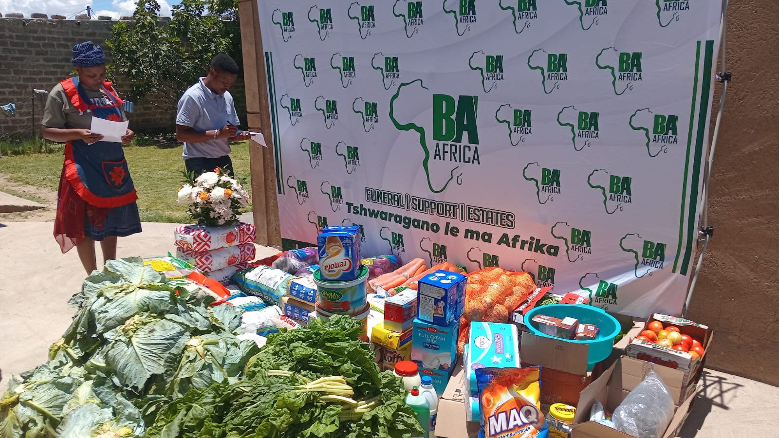 A BaAfrica grocery delivery laid out in front of the company banner