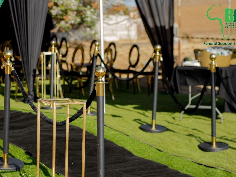 Gold stanchions and black rope marking the walkway at a graveside